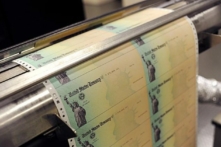 Các tờ chi phiếu trống của Bộ Ngân khố Hoa Kỳ chạy qua một máy in tại cơ sở của bộ ở Philadelphia, Pennsylvania. (Ảnh: William Thomas Cain/Getty Images)