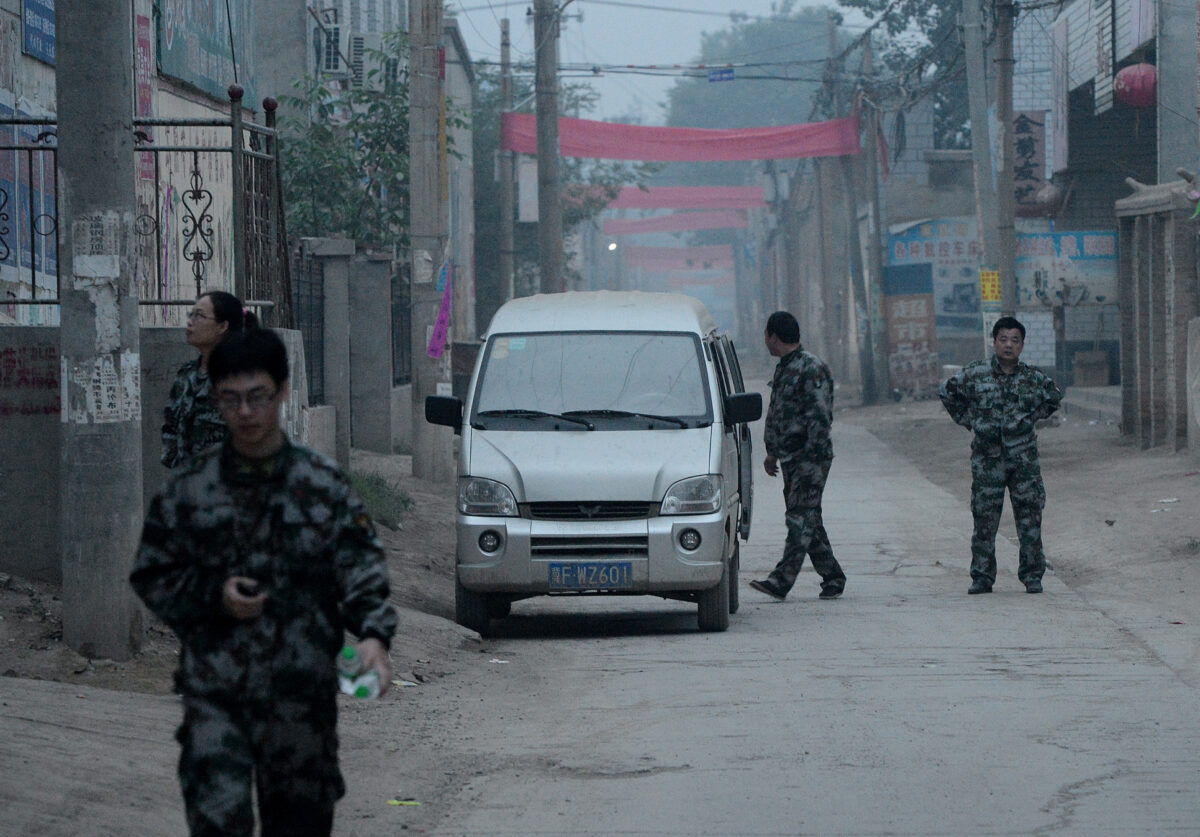 Nhân viên an ninh Trung Quốc tuần tra trên đường phố trước khi một cuộc diễn hành tôn giáo bắt đầu tại nhà thờ Công Giáo ở Đông Lư, tỉnh Hà Bắc, ngày 26/05/2013. Công an đã bao vây một ngôi làng Trung Quốc để ngăn cản những người hành hương tham gia cuộc diễn hành Công Giáo để tôn vinh Đức Trinh Nữ Maria. (Ảnh: Mark Ralston/AFP qua Getty Images)