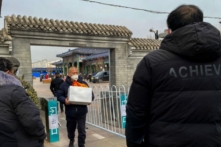 Một người đàn ông ôm bình đựng tro cốt của người thân tại một lò hỏa táng ở Bắc Kinh hôm 20/12/2022. (Ảnh: Noel Celis/AFP qua Getty Images)