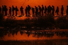 Những người nhập cư bất hợp pháp đi trong một đoàn lữ hành hơn một ngàn người từ các quốc gia như Nicaragua, Peru, Ecuador, Colombia, Venezuela, và Cộng hòa Dominica vượt sông Rio Grande để xin tị nạn chính trị tại Hoa Kỳ, ở Ciudad Juarez, tiểu bang Chihuahua, Mexico, hôm 11/12/2022. (Ảnh: Herika Martinez/AFP qua Getty Images)