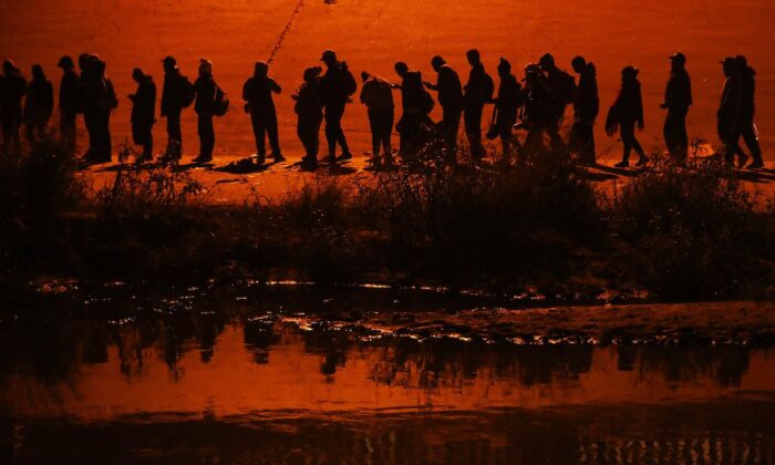 Những người nhập cư bất hợp pháp đi trong một đoàn lữ hành hơn một ngàn người từ các quốc gia như Nicaragua, Peru, Ecuador, Colombia, Venezuela, và Cộng hòa Dominica vượt sông Rio Grande để xin tị nạn chính trị tại Hoa Kỳ, ở Ciudad Juarez, tiểu bang Chihuahua, Mexico, hôm 11/12/2022. (Ảnh: Herika Martinez/AFP qua Getty Images)