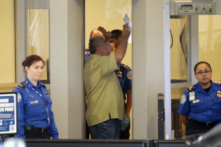 Một khách du lịch bước vào khu vực kiểm tra an ninh khi các nhân viên của Cơ quan Quản lý An ninh Giao thông kiểm tra tại Phi trường Quốc tế Los Angeles vào tháng 11/2013. (Ảnh: Kevork Djansezian/Getty Images)