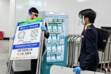 Một nhân viên tàu điện ngầm cất tấm biển có in mã sức khỏe COVID-19 được sử dụng khi vào tàu điện ngầm ở Quảng Châu, tỉnh Quảng Đông, miền nam Trung Quốc, sau khi thành phố này nới lỏng các hạn chế về COVID-19, hôm 07/12/2022. (Ảnh: CNS/AFP qua Getty Images)