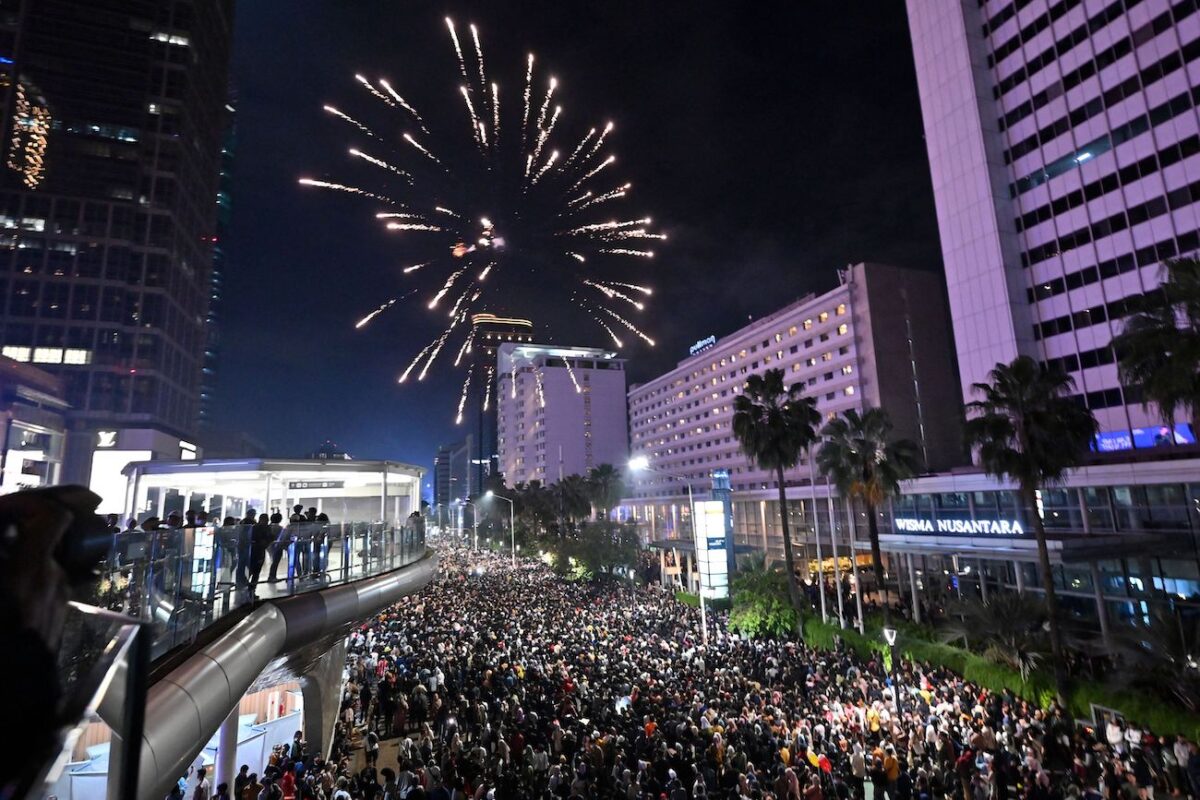 Người dân tham dự lễ kỷ niệm Năm Mới bên cạnh Đài tưởng niệm Selamat Datang (có nghĩa là ‘Chào mừng’) tại bùng binh Hotel Indonesia ở Jakarta hôm 01/01/2023. (Adek Berry/AFP qua Getty Images)