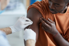 Một y tá chích vaccine vào vai một người đàn ông Mỹ gốc Phi Châu. (Ảnh: Shutterstock)
