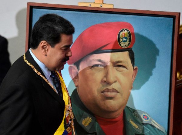 Tổng thống Venezuela Nicolas Maduro đi ngang qua bức chân dung của cố Tổng thống Venezuela Hugo Chavez ở Caracas hôm 14/01/2019. (Ảnh: Federico Parra/AFP/Getty Images)