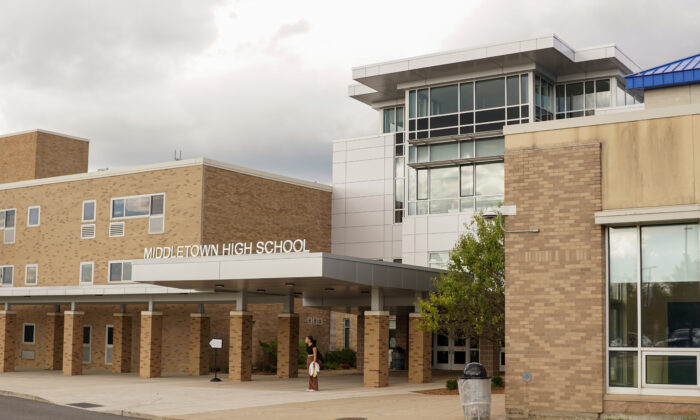 Một học sinh đợi ở lối vào tòa nhà của Trường Trung học Cơ sở sau khi tan học ở Middletown, New York, vào ngày 20/09/2022. (Ảnh: Cara Ding/The Epoch Times)