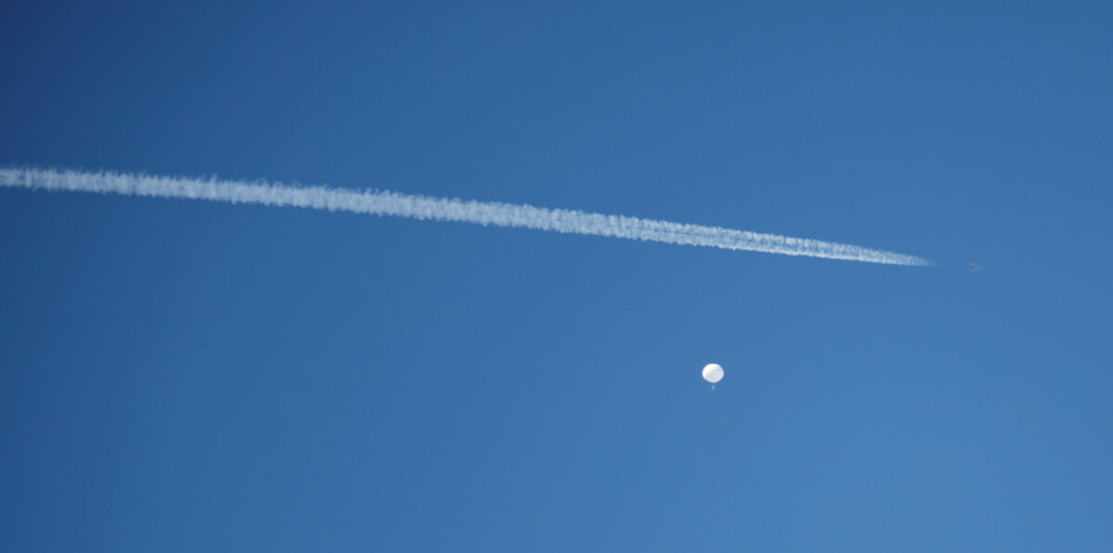 Một phản lực cơ bay ngang qua một khinh khí cầu bị tình nghi là công cụ do thám của Trung Quốc khi khí cầu này lơ lửng ngoài khơi bờ biển Surfside Beach, South Carolina, vào ngày 04/02/2023. (Ảnh: Randall Hill/Reuters)