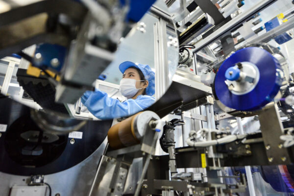 Hình ảnh phản chiếu của một công nhân trên gương đang thao tác trên dây chuyền sản xuất pin lithium-ion tại một nhà máy ở Hồ Châu, Trung Quốc, thuộc sở hữu của Microvast Holdings, mà công ty con có trụ sở tại Texas của công ty này đủ điều kiện đàm phán để nhận khoản tài trợ 200 triệu USD của Bộ Năng lượng Hoa Kỳ để chế tạo pin lithium tại Hoa Kỳ. (Ảnh: Stringer/Reuters)