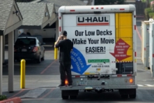 Một người đang nói chuyện qua điện thoại di động khi đang đứng phía sau một chiếc xe tải đang di chuyển ở Pacifica, California, vào ngày 26/01/2016. (Ảnh: Josh Edelson/AFP qua Getty Images)