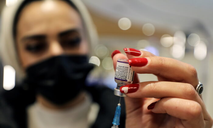 Một nhân viên y tế chuẩn bị một liều vaccine COVID-19 của Pfizer-BioNTech tại Malcha Mall, Jerusalem, ngày 22/12/2021. (Ảnh: Ammar Awad/Reuters)