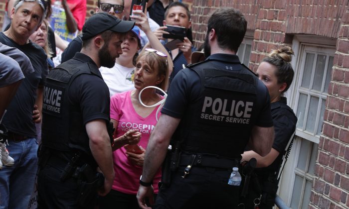 Các sĩ quan của Sở Mật vụ Hoa Kỳ ngăn các nhà hoạt động của một tổ chức bảo vệ đại sứ quán, trong đó có bà Medea Benjamin của tổ chức Code Pink, tiếp cận lối vào phía sau của Đại sứ quán Venezuela trong một cuộc đối đầu với những người ủng hộ lãnh đạo phe đối lập Venezuela Juan Guaido ở Hoa Thịnh Đốn, vào ngày 02/05/2019. (Ảnh: Alex Wong/Getty Images)