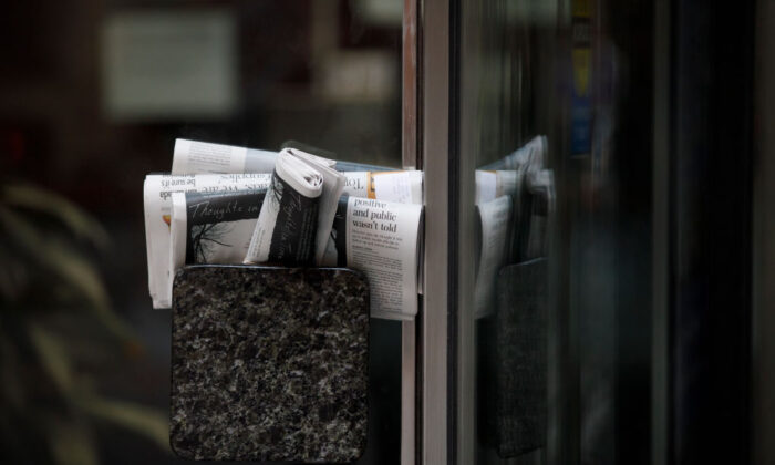 Những chồng báo được nhét vào tay nắm cửa của một tòa nhà đóng cửa ở Toronto vào ngày 01/04/2020. (Ảnh: Cole Burston/Getty Images)