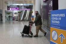 Một du khách đi ngang qua một biển xét nghiệm COVID-19 tại Phi trường Quốc tế Pearson vào ngày 03/12/2021. (Ảnh: Nathan Denette/The Canadian Press)