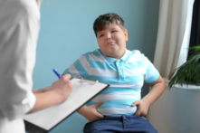 Cậu bé thừa cân tư vấn với bác sĩ tại văn phòng. (Ảnh: Shutterstock)