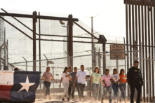 Những người nhập cư trái phép lên xe tải sau khi chờ dọc theo bức tường biên giới để đầu hàng trước các nhân viên Tuần tra Biên giới của Cục Hải quan và Biên phòng Hoa Kỳ (CBP) để được làm thủ tục nhập cư và yêu cầu tị nạn, sau khi băng qua sông Rio Grande vào Hoa Kỳ trên biên giới Hoa Kỳ-Mexico ở El Paso, Texas, hôm 11/05/2023. (Ảnh: Patrick T. Fallon/AFP qua Getty Images)