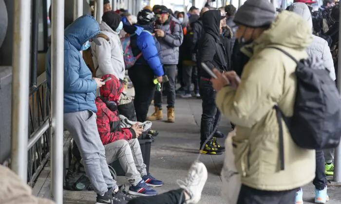 Người nhập cư bất hợp pháp cùng đồ dùng cá nhân trên vỉa hè bên ngoài khách sạn Watson ở New York ngày 30/01/2023. (Ảnh: Seth Wenig/AP Photo)