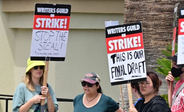 Các nhà biên kịch giương các biển hiệu trong khi biểu tình trước hãng phim Paramount ở Los Angeles hôm 15/05/2023, khi cuộc đình công của Hiệp hội Biên kịch Mỹ bước sang tuần thứ ba. Hàng ngàn nhà biên kịch biểu tình nói rằng họ đang đình công để đòi được bồi thường tốt hơn trong một lĩnh vực đã bị phá hoại bởi ngành công nghiệp phát trực tuyến. Các nhà biên kịch cho biết họ đang tìm kiếm điều kiện làm việc ổn định hơn và một tỷ lệ nhuận bút tốt hơn do sự gia tăng của các chương trình phát trực tuyến. (Ảnh: Frederic J. Brown/AFP qua Getty Images)