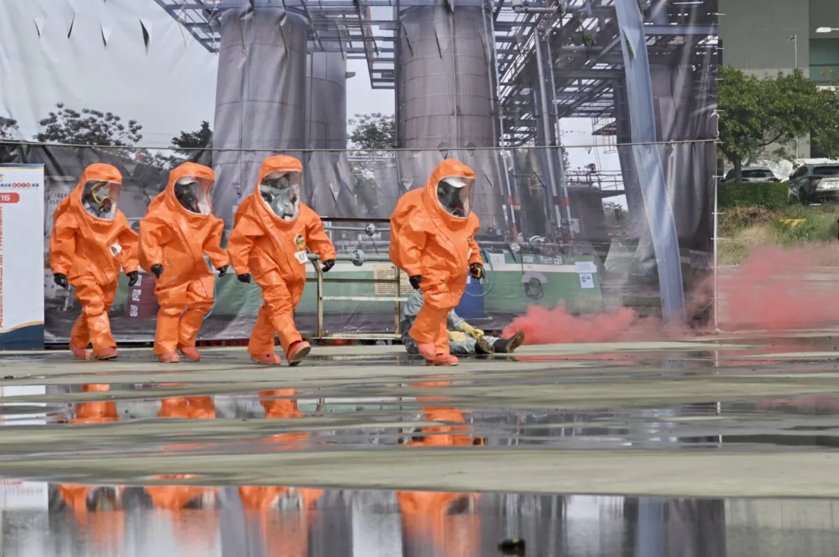 Lực lượng cứu hộ trong trang bị bảo hộ đi ngang qua một nhà máy điện hạt nhân giả bị sập trong một cuộc diễn tập dân sự khi mô phỏng một cuộc tấn công của Trung Quốc ở Đài Trung, Đài Loan, hôm 13/04/2023. (Ảnh: Sam Yeh/AFP qua Getty Images)