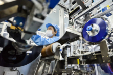 Hình ảnh phản chiếu của một công nhân trên một chiếc gương cho thấy một dây chuyền sản xuất pin lithium-ion tại một nhà máy ở Hồ Châu, Trung Quốc. Công ty này thuộc sở hữu của Microvast Holdings có công ty con đặt tại Texas vốn có đủ điều kiện đàm phán để nhận khoản tài trợ 200 triệu USD của Bộ Năng lượng Hoa Kỳ để chế tạo pin lithium tại Hoa Kỳ. (Ảnh: Stringer/Reuters)