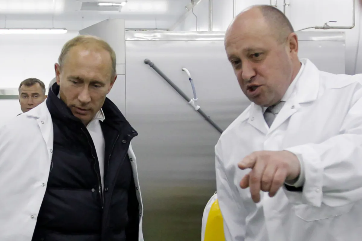 Doanh nhân Yevgeny Prigozhin hướng dẫn Thủ tướng Nga Vladimir Putin thăm nhà máy sản xuất bữa ăn trưa cho học sinh của ông bên ngoài Saint Petersburg vào ngày 20/09/2010. Doanh nhân Yevgeny Prigozhin có mối quan hệ với Điện Kremlin đã đệ đơn kiện lên một tòa án EU để rút tên ông ra khỏi danh sách trừng phạt của khối này, công ty của ông cho biết vào ngày 15/12/2020. Hồi tháng 10/2010, Liên minh u Châu đã trừng phạt ông Prigozhin — có biệt danh “đầu bếp của ông Putin” vì công ty Concord của ông đã phục vụ bữa ăn cho Điện Kremlin — cáo buộc ông phá hoại hòa bình ở Libya bằng cách trợ giúp cho công ty quân sự tư nhân Wagner Group. (Ảnh: Alexey Druzhinin/Sputnik/AFP qua Getty Images)