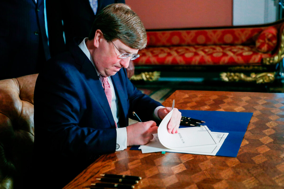 Thống đốc Mississippi Tate Reeves ký dự luật gỡ bỏ lá cờ tiểu bang cuối cùng có biểu tượng cuộc chiến của Liên minh miền Nam trong một buổi lễ tại Dinh thự của Thống đốc ở Jackson, Mississippi, vào ngày 30/06/2020. (Ảnh: Rogelio V. Solis/AFP qua Getty Images)