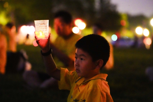 Các học viên Pháp Luân Công cầm nến trong buổi lễ thắp nến tưởng niệm các học viên Pháp Luân Công đã qua đời sau 24 năm bức hại của Đảng Cộng sản Trung Quốc tại công viên National Mall ở thủ đô Hoa Thịnh Đốn hôm 20/07/2023. (Ảnh: Madalina Vasiliu/The Epoch Times)