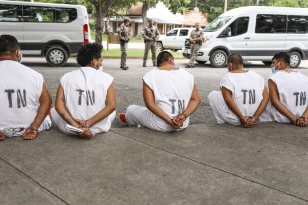 Những người nhập cư bất hợp pháp chờ bị xét xử về tội xâm phạm ở Quận Kinney bên ngoài Văn phòng Cảnh sát trưởng ở Brackettville, Texas, vào ngày 06/08/2021. (Ảnh: Charlotte Cuthbertson/The Epoch Times)