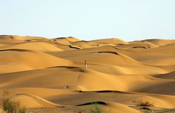 Một du khách đứng trên sa mạc Taklamakan gần huyện Vu Điền, Khu tự trị Tân Cương, Trung Quốc vào ngày 12/10/2006. (Ảnh: Guang Niu/Getty Images)