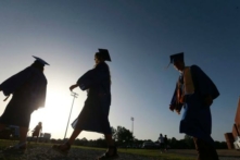 Các học sinh cuối cấp trung học tiến đến sân bóng khi mặt trời bắt đầu lặn để dự lễ tốt nghiệp ở Saltillo, Mississippi, vào ngày 27/06/2020. (Ảnh: Thomas Wells/Nhật báo The Northeast Mississippi qua AP, Tư liệu)