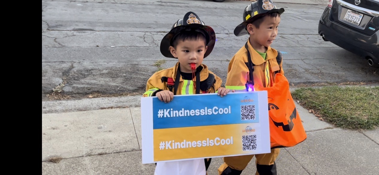 Halloween năm nay, các em nhỏ đến nhà ông Robert xin kẹo đã chụp ảnh cùng tấm bảng quảng cáo “Sự tử tế thật tuyệt.” (Ảnh do người được phỏng vấn cung cấp)