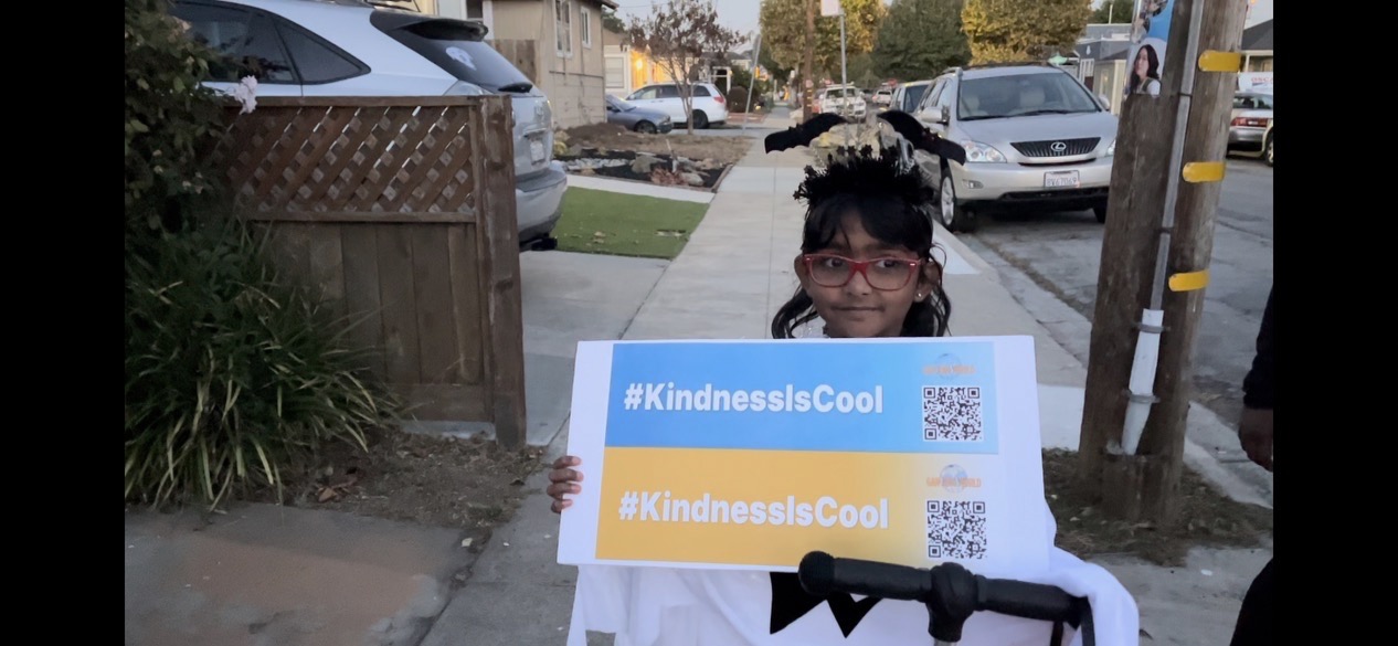 Dịp Halloween năm nay, những trẻ em đến nhà ông Robert xin kẹo đã chụp ảnh cùng tấm bích chương “Sự tử tế thật tuyệt.” (Ảnh do người được phỏng vấn cung cấp)