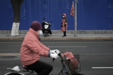 Trong những tháng gần đây, ĐCSTQ đã quảng bá mạnh mẽ “kinh nghiệm Phong Kiều,” các nhân viên an ninh quốc gia cũng đang hoạt động tích cực. Ảnh chụp một nhân viên ổn định xã hội đeo băng tay màu đỏ (bên kia đường) đang tuần tra trên đường phố Bắc Kinh. (Ảnh: Wang Zhao/AFP)