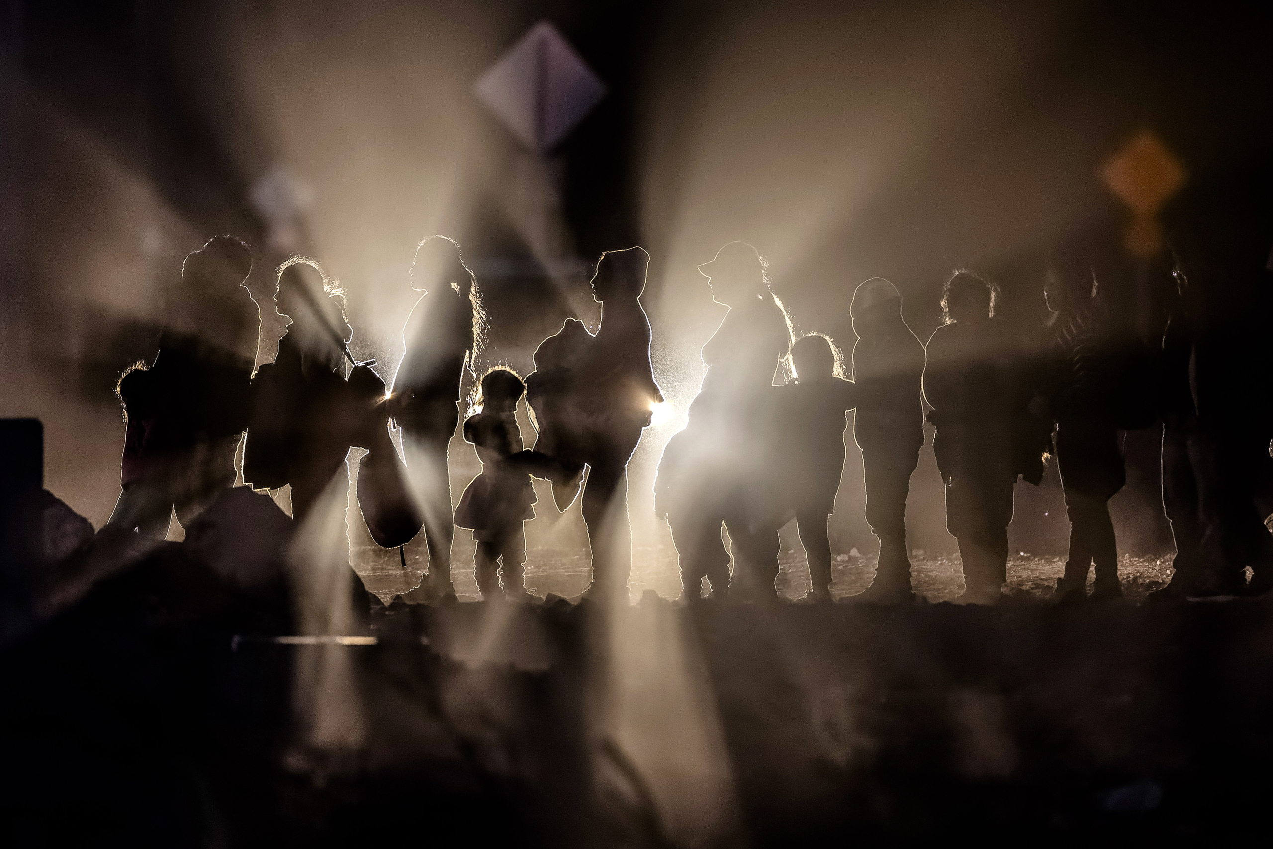 Những người nhập cư bất hợp pháp đang chờ Lực lượng Tuần tra Biên giới giải quyết sau khi băng qua biên giới Hoa Kỳ-Mexico ở Lukeville, Arizona, hôm 05/12/2023. (Ảnh: John Moore/Getty Images)