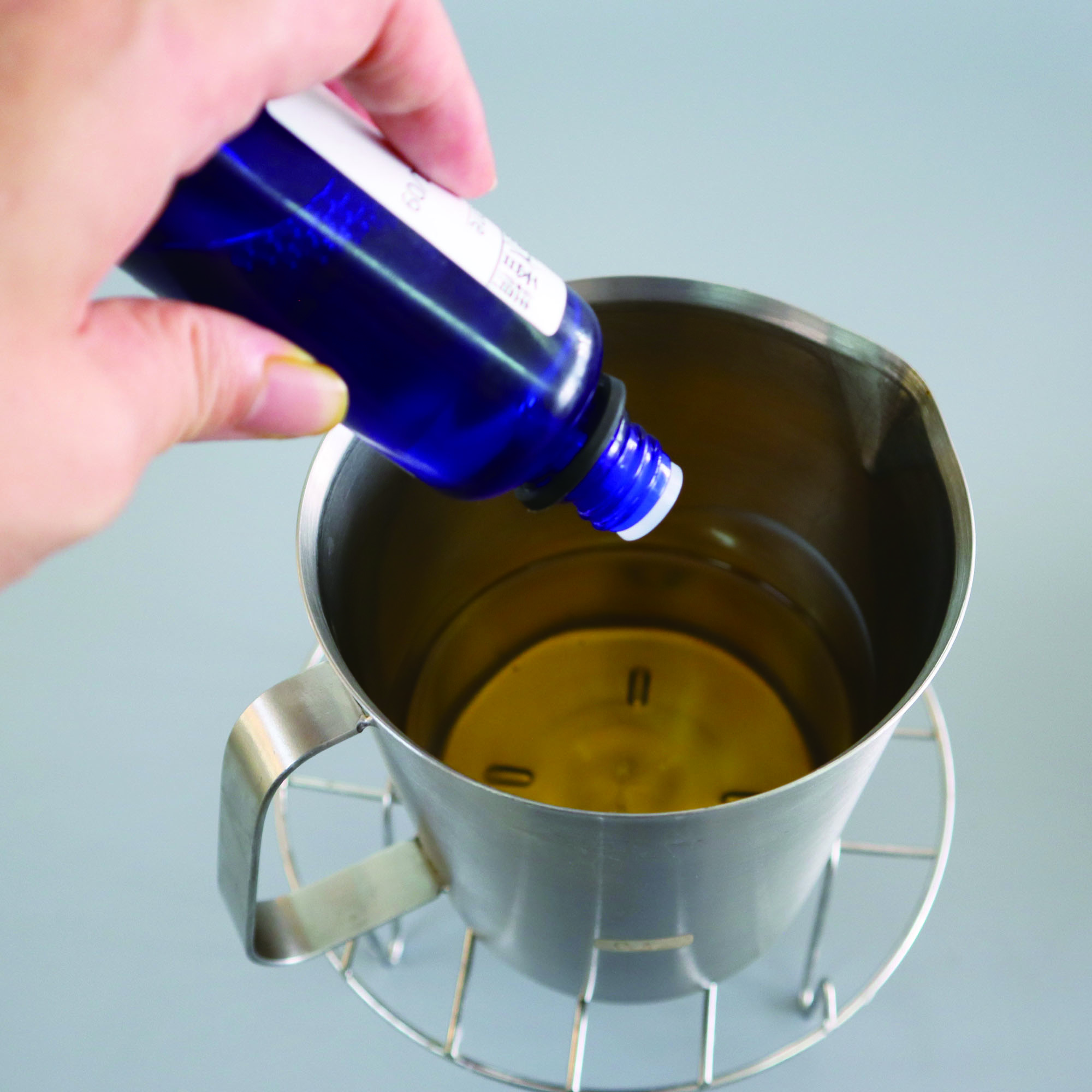 Thêm hương thơm vào sáp lỏng. (Ảnh: Nhà xuất bản Văn hóa Xuất Sắc)