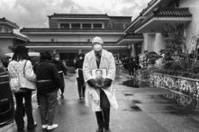 Một người đưa tang trong trang phục tang lễ màu trắng truyền thống cầm di ảnh thân nhân tại một nhà tang lễ ở Thượng Hải, Trung Quốc, vào ngày 14/01/2023. (Ảnh: Kevin Frayer/Getty Images)