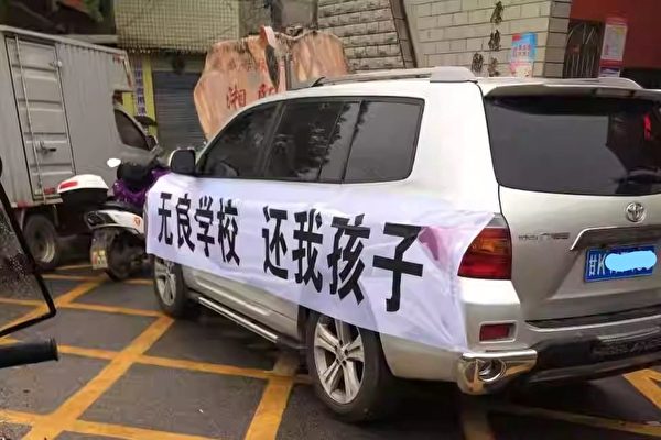 Một chiếc xe tải treo biểu ngữ “Trường học vô đạo đức, hãy trả lại con cho tôi” dừng trước Trường Dạy nghề Trung Sơn ở tỉnh Hồ Nam, Trung Quốc hồi tháng 05/2023. (Ảnh: Đăng dưới sự cho phép của anh Lý Trúc)