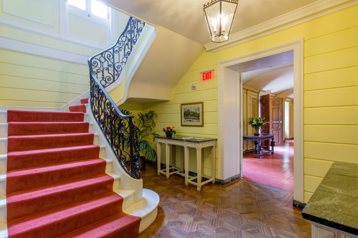 Sự sang trọng tinh tế có thể được nhìn thấy ở chiếc cầu thang trong nhà nữ văn sỹ Wharton, tuy đúc hẫng nhưng không quá đồ sộ. Chiếc cầu thang chính tựa vào bức tường lát gỗ này nằm tách biệt bên ngoài sảnh vào thân mật — trông như một chiếc hang động, với mặt sàn lát đất nung có tông màu nâu đậm. (Ảnh: Nhiếp ảnh gia Eric Limon)