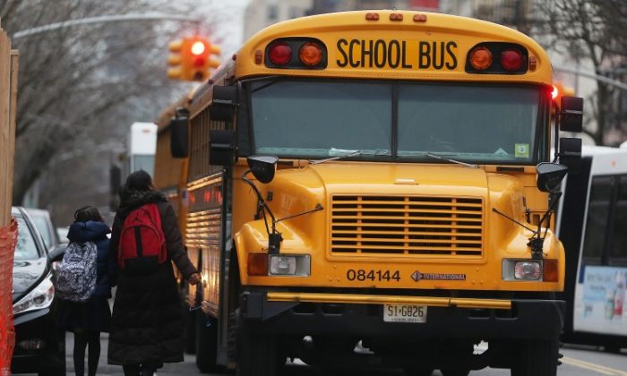 Học sinh đi bộ lên xe buýt trường học ở Manhattan vào ngày 15/01/2013. (Ảnh: Mario Tama/Getty Images)