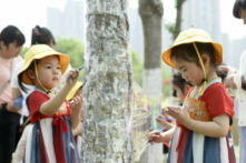 Trẻ em vẽ trên tấm nilon tại một công viên vào Ngày Quốc tế Thiếu nhi ở Hải An, Giang Tô, miền đông Trung Quốc, vào ngày 01/06/2022 (Ảnh: STR/AFP qua Getty Images)