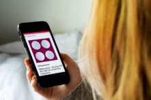 Một người phụ nữ nhìn vào viên thuốc phá thai—RU-486, hay mifepristone—trên điện thoại, ở Arlington, Virginia, vào ngày 08/05/2020. (Ảnh: Olivier Douliery/AFP qua Getty Images)