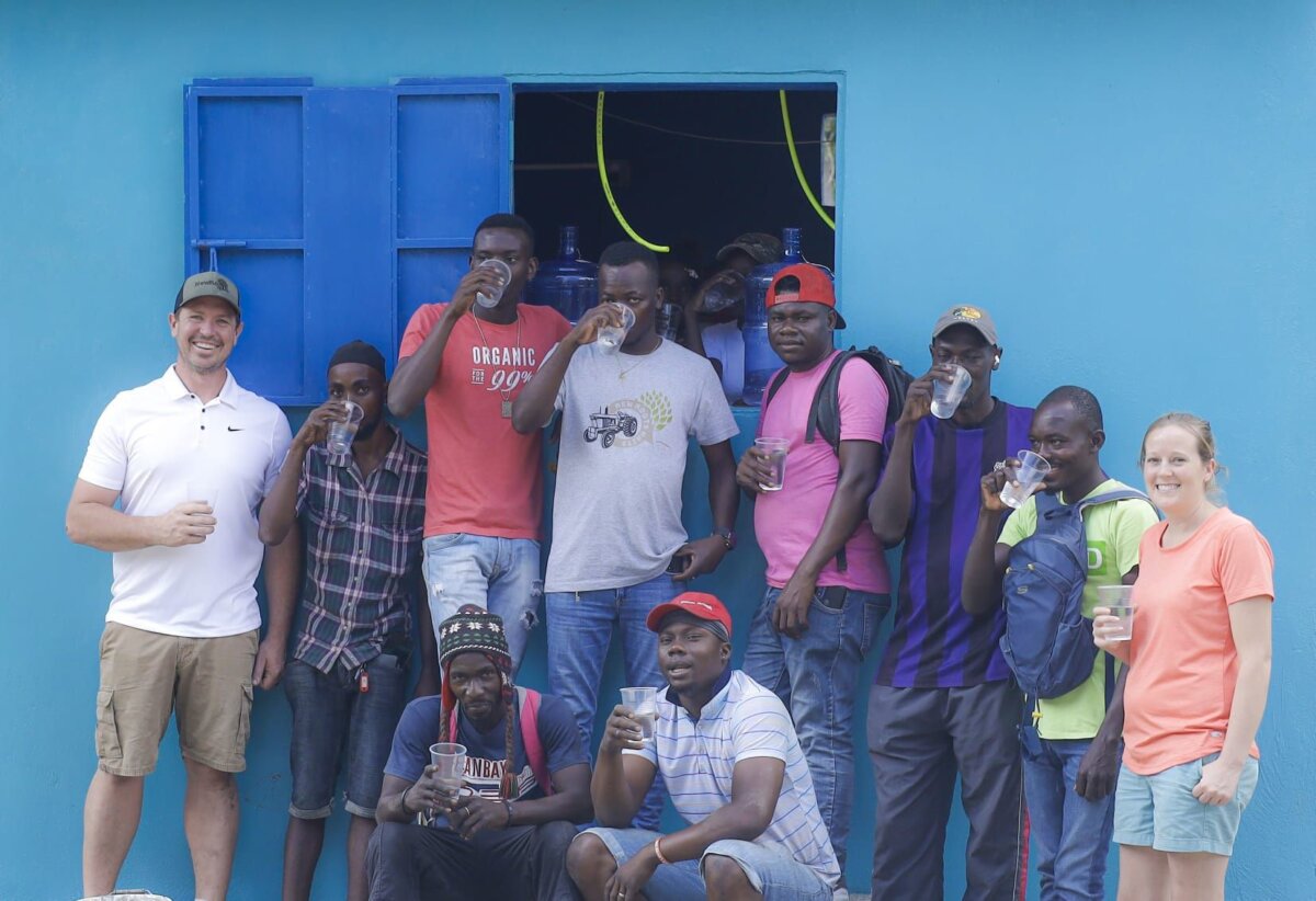 Ông Nick và bà Nikki Stolberg ở New Roots, gần Cap-Haitien, Haiti, cầm ly nước với một số nông dân ở New Roots. (Ảnh: Alexis Wood-Ally Julien/New Roots)