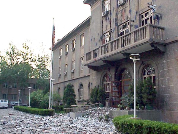 Quang cảnh lối vào chính bị hư hại của đại sứ quán Hoa Kỳ ở Bắc Kinh vào ngày 10/05/1999 trong thời gian tạm lắng cuộc biểu tình phản đối vụ đánh bom của NATO vào đại sứ quán Trung Quốc ở Belgrade. Bỏ qua những lời chia buồn và bày tỏ tiếc nuối của Tổng thống Hoa Kỳ Bill Clinton cùng các lãnh đạo NATO khác, có tới 100,000 người biểu tình tràn ra các đường phố xung quanh đại sứ quán Hoa Kỳ ở Bắc Kinh trong cuộc biểu tình lớn nhất từng thấy ở thủ đô này kể từ phong trào ủng hộ dân chủ năm 1989. (Ảnh: Đại sứ quán Hoa Kỳ/AFP)