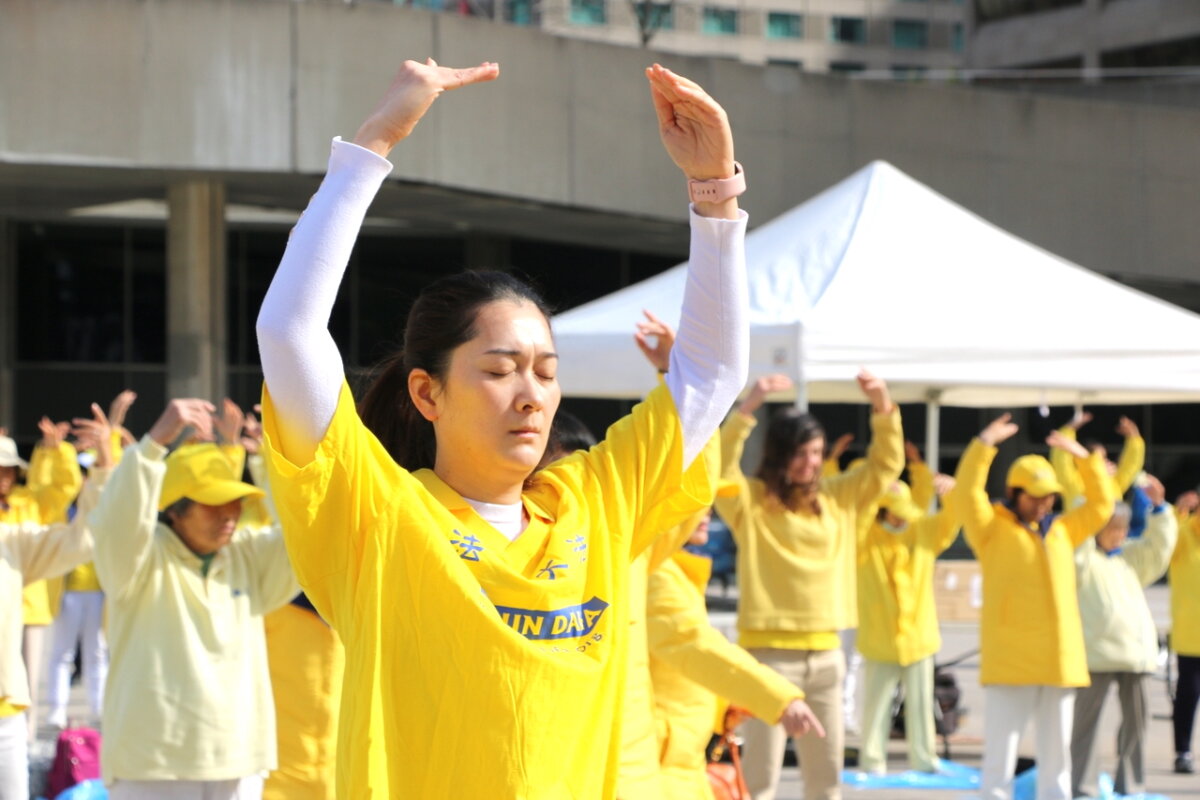 Các học viên Pháp Luân Công trình diễn các bài công pháp của họ nhân dịp kỷ niệm Ngày Pháp Luân Đại Pháp Thế giới lần thứ 32 bên ngoài Tòa thị chính Toronto, hôm 11/05/2024. (Ảnh: Andrew Chen/The Epoch Times)