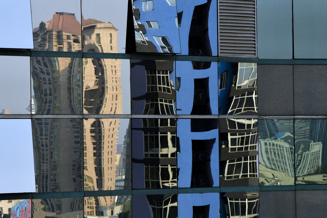 Các tòa nhà cao tầng được phản chiếu trên cửa sổ của một tòa nhà văn phòng ở Bắc Kinh ngày 06/05/2013. (Ảnh: Mark Ralston/AFP/Getty Images)