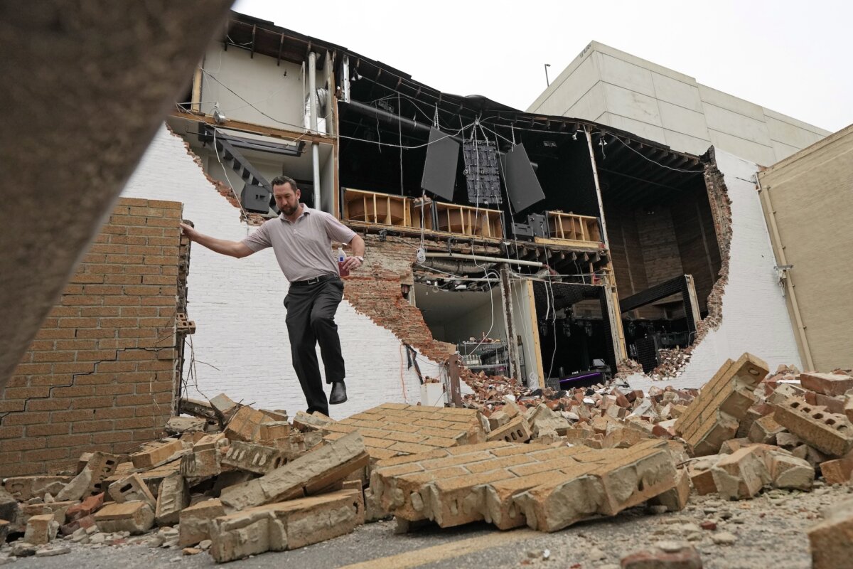 Một người đàn ông đi trên những viên gạch rơi từ một tòa nhà bị hư hại sau cơn giông bão dữ dội, ở Houston, Texas, hôm 17/05/2024. (Ảnh David J. Phillip/AP Photo)