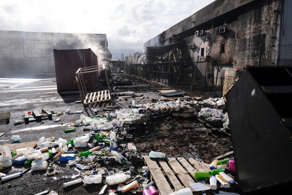 Chai lọ và mảnh vụn vứt khắp mặt đất ở khu công nghiệp Normandy ở Nouméa, New Caledonia, hôm 20/05/2024. (Ảnh: Theo Rouby/AFP qua Getty Images)