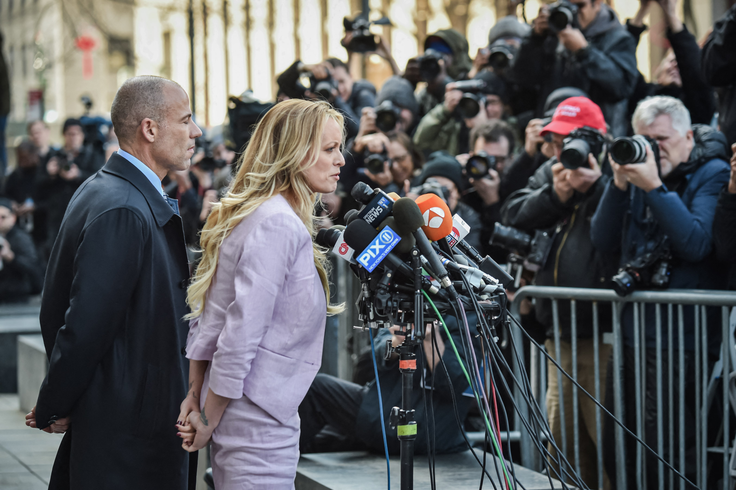 Nữ diễn viên phim người lớn Stephanie Clifford, (ở giữa) còn được gọi là Stormy Daniels, nói với giới truyền thông bên cạnh luật sư của bà, ông Michael Avenatti, sau một phiên tòa ở thành phố New York, vào ngày 16/04/2018. (Ảnh: Hector Retamal/AFP qua Getty Images)