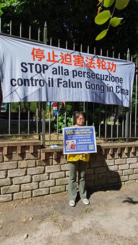 Học viên Pháp Luân Công Triệu Lý Lực cầm tấm biển ghi “Giúp cứu người thân.” (Ảnh: The Epoch Times)