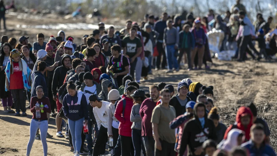 Hơn một ngàn người nhập cư bất hợp pháp xếp hàng chờ để được các nhân viên Tuần tra Biên giới Hoa Kỳ giải quyết ở Eagle Pass, Texas sau khi vượt sông Rio Grande từ Mexico, hôm 18/12/2023. (Ảnh: John Moore/Getty Images)
